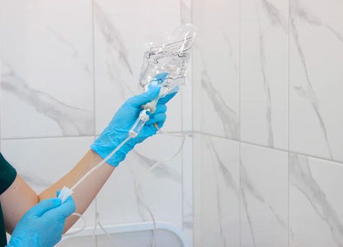 Врач подготавливает капельницу